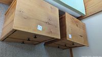 Two wooden bedside tables viewed from above, showing the tops of both tables with natural wood grain.