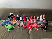 Photo of 22 assorted Beanie Babies arranged showing birds and sea creatures on a couch.