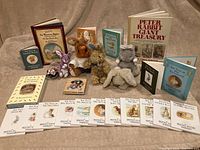 Overview photo showing Beatrix Potter books and plush bunnies arranged on fabric.