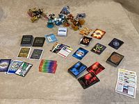 Overview of various trading cards laid flat including Magic: The Gathering cards, and assorted cards from other series; Skylanders figures arranged behind cards.
