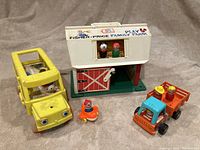 Photo of the full set showing the white fishing price barn with figures inside, yellow bus, orange truck, duck figure, and plastic dog