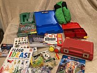 Wide shot of lot showing three Lego storage cases (red, blue, and green), seven Lego books/manuals including Lego Ideas, Mindstorms Chain Reactions, Architecture, and Harry Potter, plus misc pieces and toys.