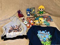 Photo showing the entirety of the lot with Nintendo Switch dock, plush toys, guidebooks, shirts, and figures
