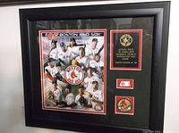 Front view of framed 2005 Boston Red Sox team picture with plaque and embedded game-used ball piece.