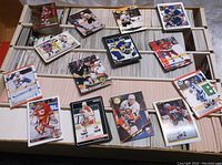 Wide view of over a dozen scattered stacks and piles of loose hockey cards in various small groupings.