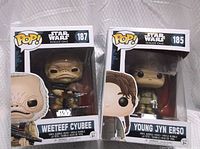 Front view of two Star Wars Pop Figures in original boxes: Weeteef Cyubee #187 on left and Young Jyn Erso #185 on right.