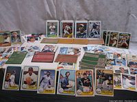 Overview of assorted vintage baseball cards spread out, showing front player images and backs with stats, from 1976 to 1989.