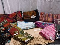 A selection of assorted scarves showing various colors and patterns laid out flat on a surface.