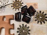 Clock DIY parts arranged showing wooden puzzle piece bases, decorative clock hands, and black plastic clock mechanisms.