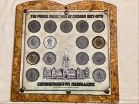 Full view of the mounted board displaying 18 Canadian Prime Ministers commemorative coins from 1867 to 1970 with a Parliament building image