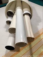 Photo of ten rolled posters grouped together, showing different diameters and some visible print on edges.
