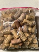 Bag of over 40 natural cork wine stoppers showing assorted imprints and markings