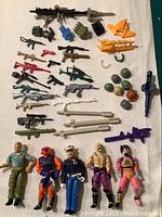 Array of firearms, ammo packs, missiles, weapon attachments, helmets and figures on white background