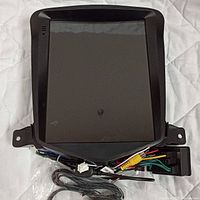 Front view of Android car touchscreen display in black plastic frame with wiring connectors visible below