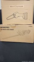 Stacked cardboard boxes labeled Mini Chainsaw and WorkPro 20V Cordless Hedge Trimmer