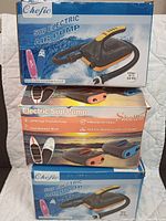 Three boxes of electric SUP air pumps stacked, showing front product images and brand names Chefic and Skyrella