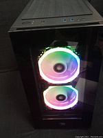 Front view of black PC tower case with tempered glass front panel and dual RGB fans
