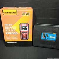 Photo showing Konnwei KW850 scan tool box next to black case for the digital lux meter