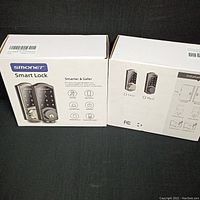 Two SMONET smart lock boxes side by side showing packaging front and side