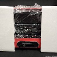 Teco multi-functional cooker partially unpacked showing red base, black control panel, and sealed in plastic with Styrofoam sides.