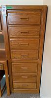 Front view of the dresser showing 7 drawers with wooden recessed handles on each.