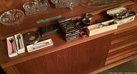 Overview of vintage and antique collectible spoons, forks, napkin rings, and other silver-plated items arranged on wooden surface