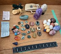 Full lot overview showing gemstones, spirit stones, crystal pendant, pouches, and ruler for scale
