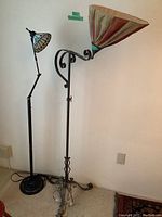 Full view of two floor lamps side by side showing fabric shade and metal framed glass shade
