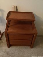 Front view of the wood nightstand with the teak breakfast tray placed on top, showing the two drawers.