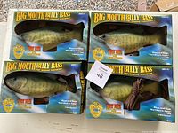 Set of 4 Big Mouth Billy Bass in original packaging arranged on ground showing box fronts.