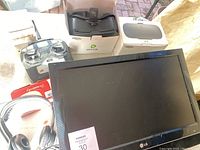Overview of all items together including LG monitor screen, gaming headset, two virtual reality headset boxes, and miscellaneous accessories.