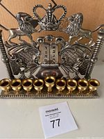 Front view of Godinger menorah made of silver plate and brass showing lions, crown, and candle holders