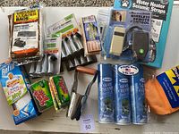 Multiple household cleaning items plus water heater seismic straps and remote control arranged in a flat lay.