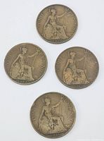 Four British one penny bronze coins from 1913, 1914, 1915, and 1916 laid out on white surface.