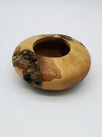 Front view of the shallow carved wood bowl showing natural wood knots and openings.