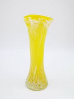 Full view of the handblown yellow and white art glass bud vase with ruffled rim against white background.