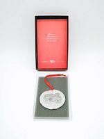 Photo of the ornament with the original box open showing the ornament in foam padding and the branded red interior lid.