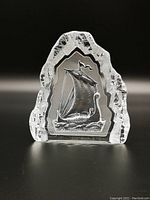 Front view of crystal glass paperweight showing engraved Viking ship inside.