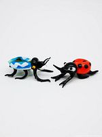 Both beetle figurines side by side showing sizes and shape differences