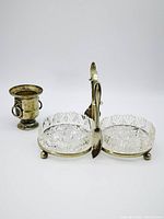 Front side view of the condiment caddy showing crystal inserts and silver plated handle with butter spreader