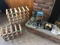 Photo of two wooden bottle racks, glass carafe, boxed wine cooler, corkscrew, coaster, and metal wine bottle labels