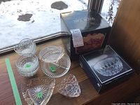 Overview of crystal and pressed glass serving ware including bowls, relish trays, and boxed items.