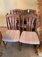 Four oak slat-back chairs grouped together in a room.