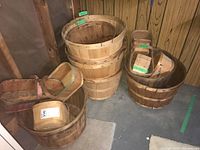 General view of the assortment of wooden bushel and fruit baskets in basement corner, stacked and nested.