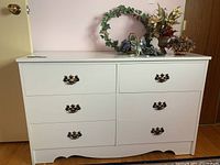 Full front view of the painted white dresser with six drawers and brass-tone handles, showing the size and style.