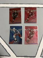 Front side of all four hockey cards in the lot showing players in action with colored background and championship branding.