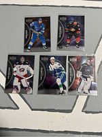 Photo of five Metal Universe hockey cards from 2021-22 series showing front art of Ryan O'Reilly, Mason McTavish, Elvis Merzlikins, Elias Pettersson, Connor Hellebuyck.