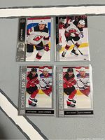 Four hockey cards front view showing Jack Hughes in New Jersey Devils uniform with two checklist cards.
