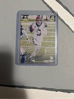 Front of Joe Burrow rookie card in plastic sleeve showing player image and autograph graphic.