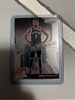 Front of Kevin Durant basketball card from 2020-21 Prizm Dominance series showing player in Brooklyn Nets uniform and holographic design